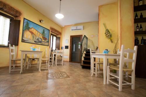 a dining room with tables and chairs and a painting on the wall at B&B Sa Lumenaria "da Raimonda" in Sorgono