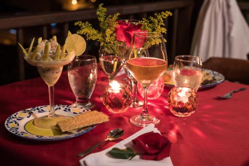 a table with glasses of wine and a plate of food at Nueva Granada Hotel Colonial -Centro Histórico- in Santa Fe de Antioquia