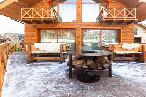 a log cabin with a table and chairs and windows at Chalets CEDER 1 in Tatranská Lomnica