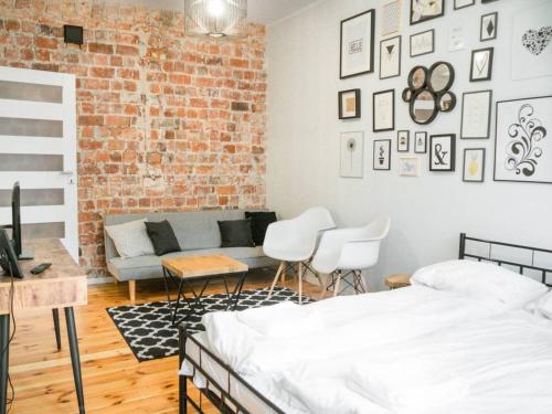 a bedroom with a brick wall and a bed and chairs at Apartament Dwa Lwy Gdańsk Stare Miasto in Gdańsk