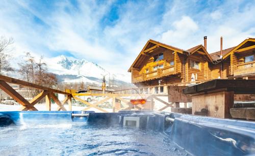 a large plunge pool in front of a log house at Chalets CEDER in Vysoke Tatry - Tatranska Lomnica.