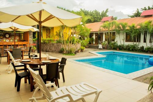 a patio with a table and chairs next to a swimming pool at Colina de Montalva in Tarapoto