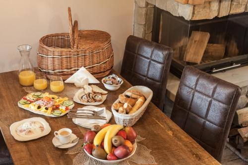 a table with fruit and baskets of food on it at Chalets CEDER 1 in Tatranská Lomnica