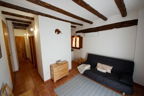 uma sala de estar com um sofá preto e uma mesa de madeira em Apartamentos Aguilar em Alcañiz