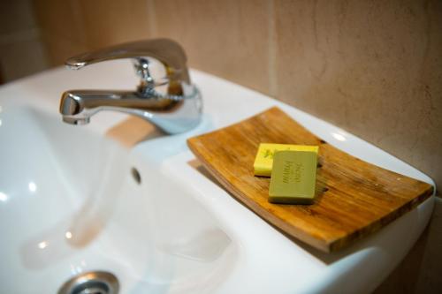 a wooden cutting board with a bar of soap on a sink at Apartamentos Aguilar in Alcañiz
