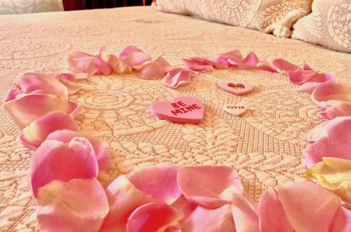 a bed with pink flowers and hearts on it at Captain's Inn at Moss Landing in Moss Landing