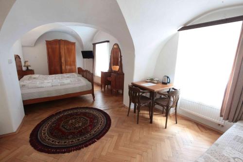 チェスケー・ブジェヨヴィツェにあるPenzion Bohemiaのベッドルーム1室(ベッド1台、テーブル、椅子付)