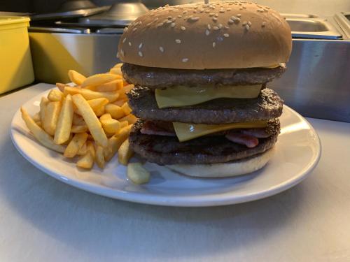 a hamburger and french fries on a white plate at Cotswold Valley Aparthotel in Stroud