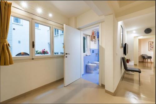 einen Flur mit einer Tür, die zu einem Bad mit WC führt in der Unterkunft Arch Apartment Duomo - Florence in Florenz