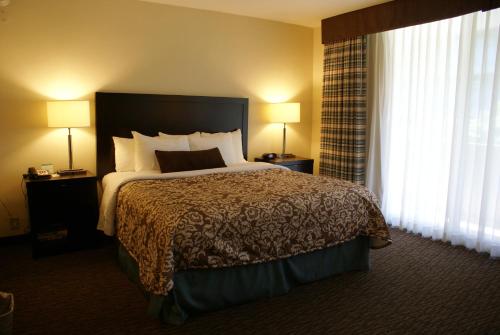 a hotel room with a large bed and two lamps at Royal Palace Westwood Hotel in Los Angeles