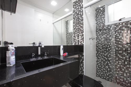 a bathroom with a black sink and a mirror at AP EXPOCENTER - ATÉ 5 HOSPEDES in Sao Paulo