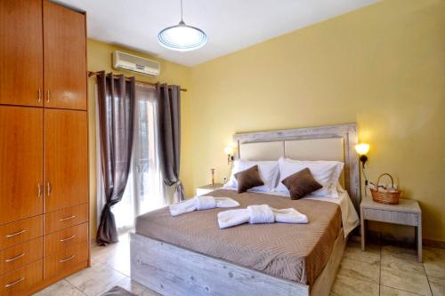 a bedroom with a bed with two towels on it at Vasos Apartment Agios Athanasios Corfu in Agrós