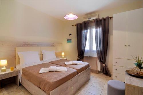 a bedroom with a large bed with towels on it at Vasos Apartment Agios Athanasios Corfu in Agrós