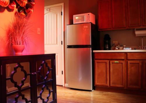 a kitchen with a stainless steel refrigerator with a microwave on top at The Grand Treehouse Resort in Eureka Springs