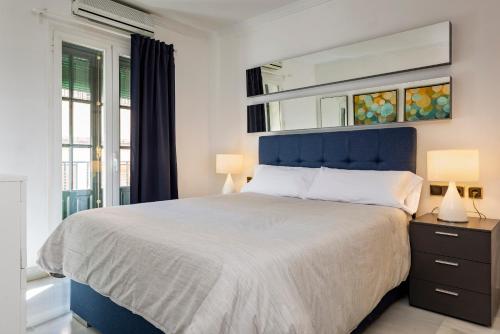 セビリアにあるLux Home - Sierpes Terraceのベッドルーム1室(大型ベッド1台、青いヘッドボード付)