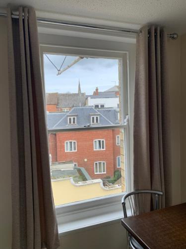 a window with a view of a building at Cotswold Valley Aparthotel in Stroud