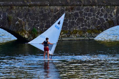 a person on a sail board in the water at Casas de Pousadouro in Baião
