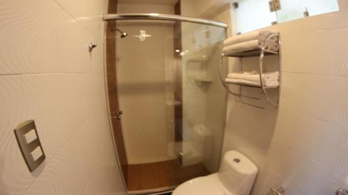 a bathroom with a toilet and a glass shower at Hotel Ottavis in Chiclayo