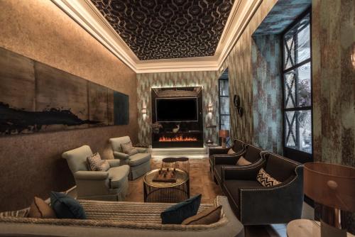 a living room with couches and a fireplace at Hotel Casa Palacio María Luisa in Jerez de la Frontera