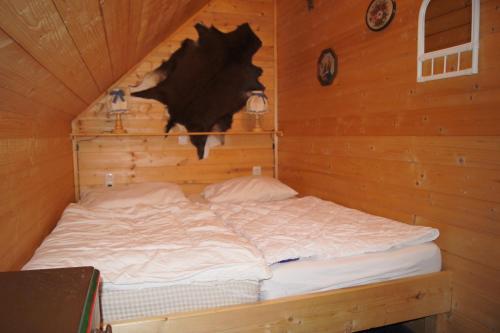 RossleithenにあるFerienhütten Brandtnerの木製の壁のキャビンのベッド1台