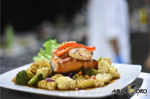 a plate of food with meat and vegetables on a table at Hotel Milla de Oro Uraba in Apartadó