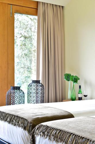 two vases sitting on a bed with a window at Casas de Pousadouro in Baião
