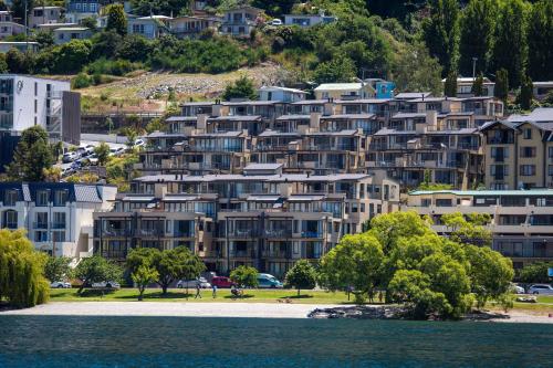 a large apartment building on a hill next to a body of water at Peppers Beacon in Queenstown