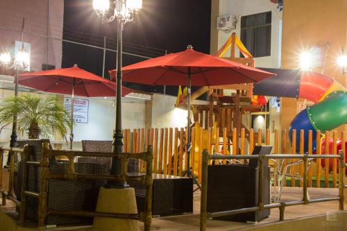 a playground with red umbrellas and a play park at MarySol Las Palmas in Rincon de Guayabitos