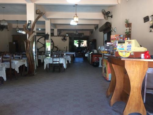 a dining room with tables and white tablecloths at Pousada Recanto de Minas in Nova Viçosa