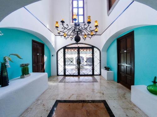 a hallway with blue walls and a chandelier at La Villa du Golf à Cancun Hotel Boutique in Cancún