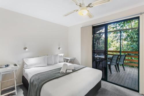 um quarto com uma cama e uma varanda com uma mesa em Ingenia Holidays Landsborough em Landsborough