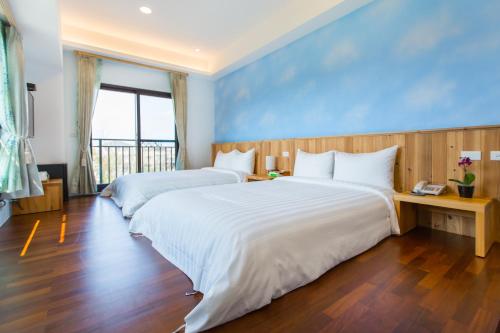 冬山鄉的住宿－後山寶典觀自在，蓝色墙壁客房的两张床