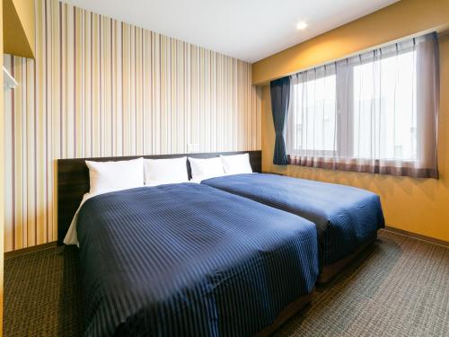 Ένα ή περισσότερα κρεβάτια σε δωμάτιο στο HOTEL LiVEMAX Sendai Aobadori