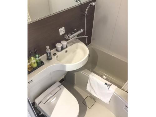 a small bathroom with a sink and a toilet at HOTEL LiVEMAX Okayama in Okayama