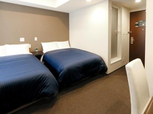 a hotel room with a bed and a door at HOTEL LiVEMAX Kayabacho in Tokyo