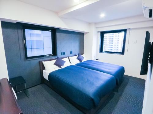 מיטה או מיטות בחדר ב-HOTEL LiVEMAX Tokyo Shintomicho