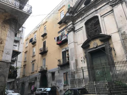 un bâtiment dans une rue avec des voitures garées devant dans l'établissement Nel Cuore di Napoli, à Naples