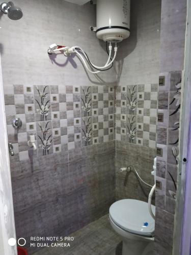 a small bathroom with a toilet and a shower at New Hotel Yatri Niwas in Varanasi