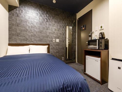 um quarto de hotel com uma cama e um micro-ondas em HOTEL LiVEMAX Asakusabashi-Ekimae em Tóquio