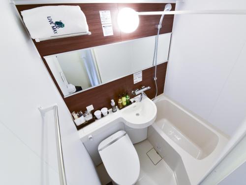 małą łazienkę z toaletą i umywalką w obiekcie HOTEL LiVEMAX Toyosu-Ekimae w Tokio