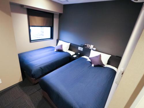 HOTEL LiVEMAX Tokyo-Otsuka Ekimae tesisinde bir odada yatak veya yataklar