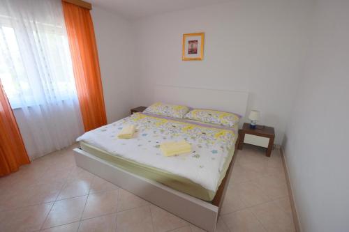 sypialnia z łóżkiem z dwoma przecznicami w obiekcie Apartments Gabrijel w mieście Malinska
