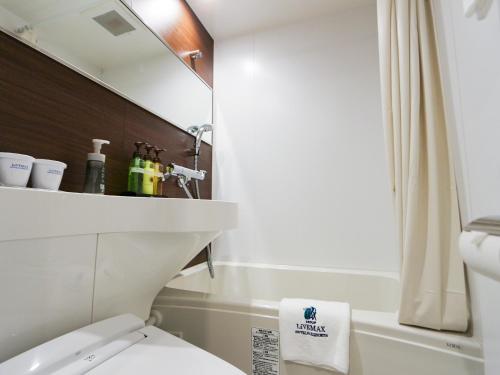 uma casa de banho com um WC, um lavatório e um espelho. em HOTEL LiVEMAX Akabane-Ekimae em Tóquio