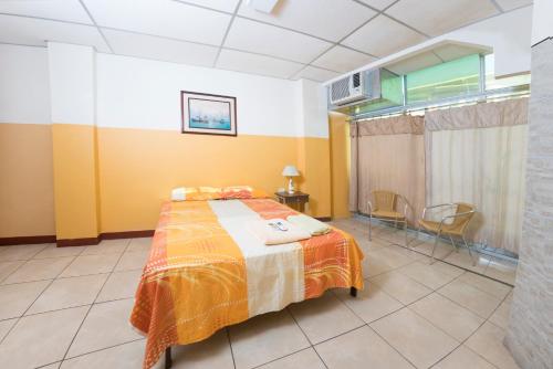 - une chambre avec un lit, une table et des chaises dans l'établissement Grand Hotel Libertad-GHL, à La Libertad