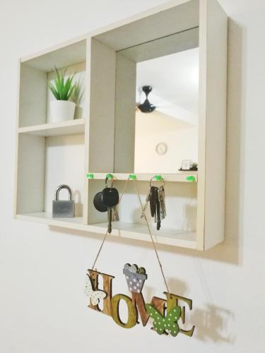 a mirror hanging on a wall with a hoo sign at AiMAS Homestay Senawang Muslim in Seremban