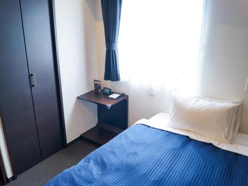 מיטה או מיטות בחדר ב-HOTEL LiVEMAX Saitama-Asaka-Ekimae