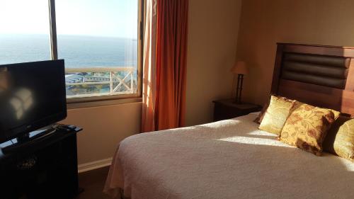 1 dormitorio con 1 cama, TV y ventana en Excellent Large Apartment with Sea View, en Viña del Mar