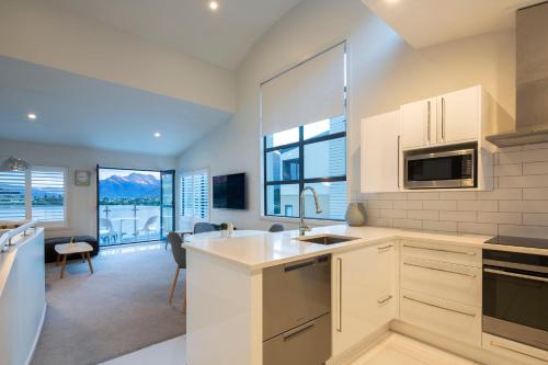 a kitchen with a sink and a stove top oven at Mantra The Point in Queenstown
