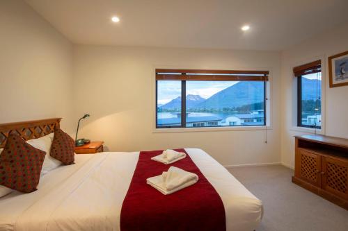 una camera da letto con un grande letto con una grande finestra di BreakFree The Point a Queenstown