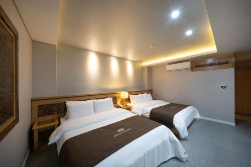 a hotel room with two beds in a room at Symphony Hotel in Suwon